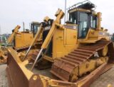 Trator de esteira Caterpillar D6R amarelo com lâmina frontal em pátio industrial