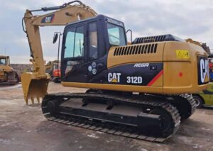 Escavadeira Caterpillar 312D amarela com esteiras, vista lateral em canteiro de obras
