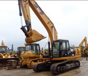Escavadeira hidráulica Caterpillar 320D/320DL amarela com braço e concha, vista lateral em canteiro de obras