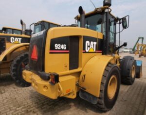 Pá carregadeira Caterpillar 924G amarela com cabine envidraçada em ambiente externo