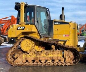 Trator de esteira Caterpillar D6N amarelo em obra, com cabine fechada e esteiras visíveis