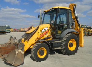 Retroescavadeira JCB amarela modelos 3CX/4CX/5CX com cabine envidraçada e braços articulados em canteiro de obras