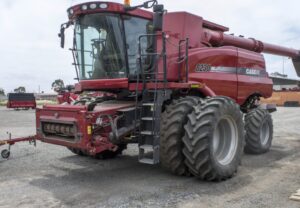 Colheitadeira Case IH Axial-Flow vermelha estacionada em pátio externo, com cabine envidraçada, pneus largos e tubo de descarga lateral